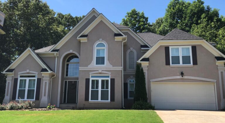 Elegant home exterior featuring double-hung vinyl windows from the 700 Series, showcasing energy-efficient glass and a stylish architectural design, surrounded by lush greenery.