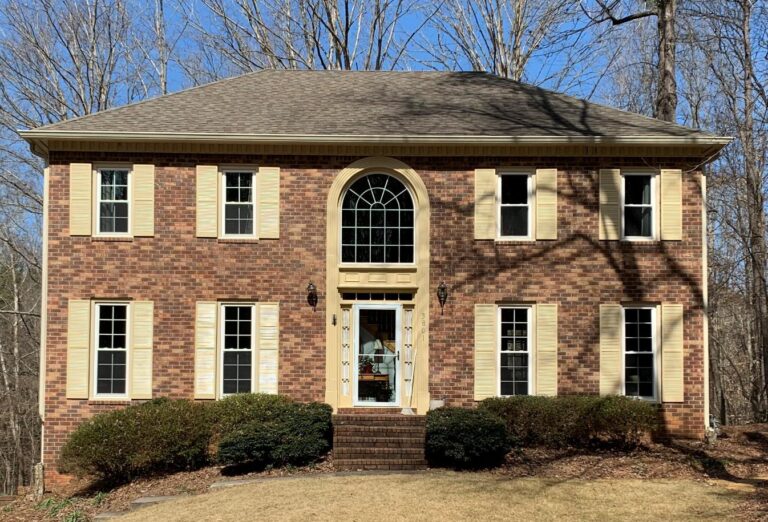 House featuring 700 Series double-hung vinyl windows, brick facade, and landscaped front yard, showcasing energy-efficient design and customizable options.