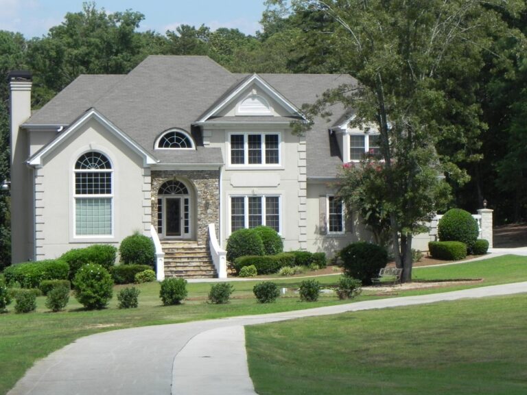 Elegant home featuring 700 Series double-hung vinyl windows, landscaped yard, and stone accents, highlighting energy-efficient design and quality craftsmanship.