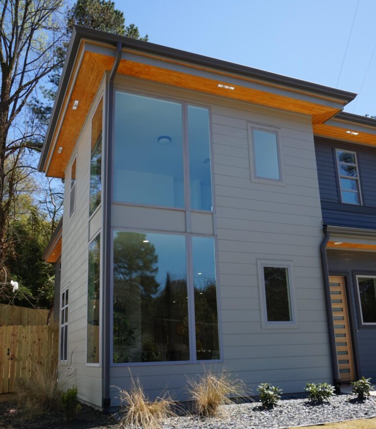 Modern home exterior showcasing large windows, emphasizing natural light and energy efficiency, featuring durable vinyl frames and a stylish design, relevant to Windowcrafters' 900 Series single-hung vinyl windows.