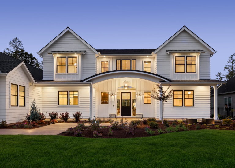 Modern residential home exterior with vinyl windows, landscaped yard, and porch, showcasing energy-efficient design and quality craftsmanship by Windowcrafters.