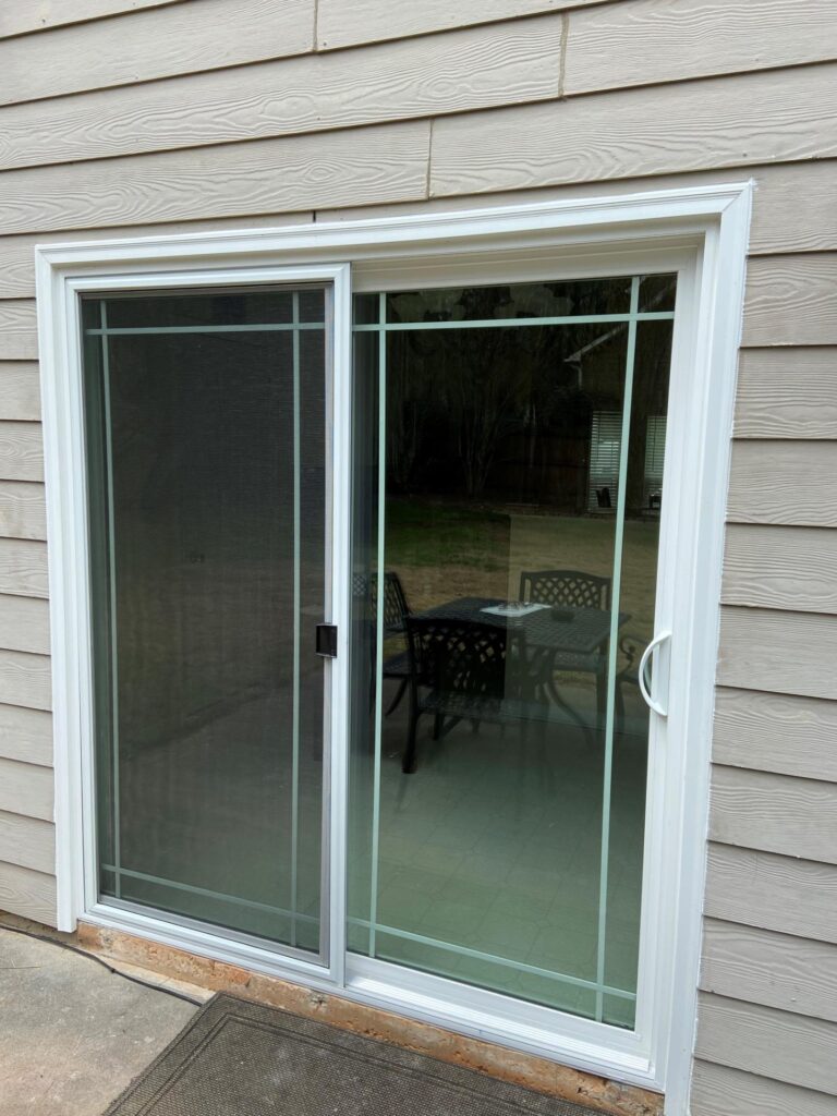Vinyl sliding door with screen, showcasing outdoor patio view, highlighting energy efficiency and design for Georgia's climate.