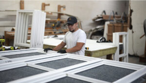 Worker assembling custom vinyl windows in a workshop, showcasing local craftsmanship for Windowcrafters in Tucker, Georgia.