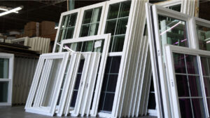 Stacks of custom vinyl windows in a warehouse, showcasing energy-efficient designs for Atlanta homes and contractors.