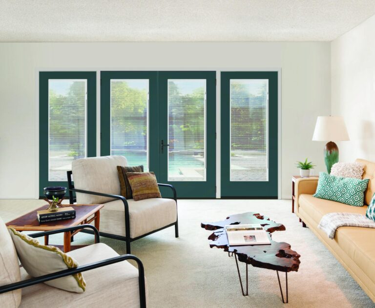 Flush-glazed double doors with integrated blinds, set in a modern living room featuring stylish furniture and a view of a pool outside.