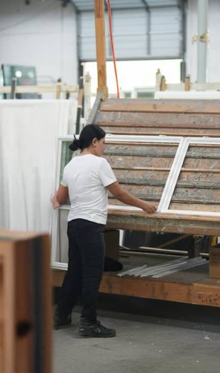Worker assembling vinyl windows in a factory setting, showcasing the in-house production process at Windowcrafters in Tucker, GA.