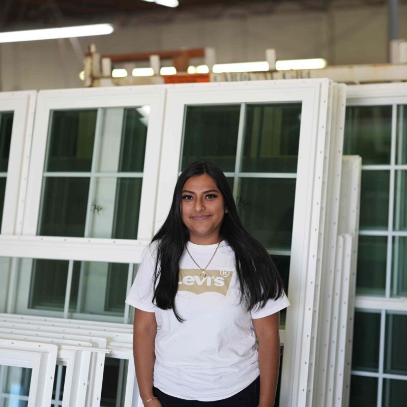 Team member standing in front of vinyl windows in the Windowcrafters factory, showcasing expertise and commitment to quality manufacturing in Georgia.